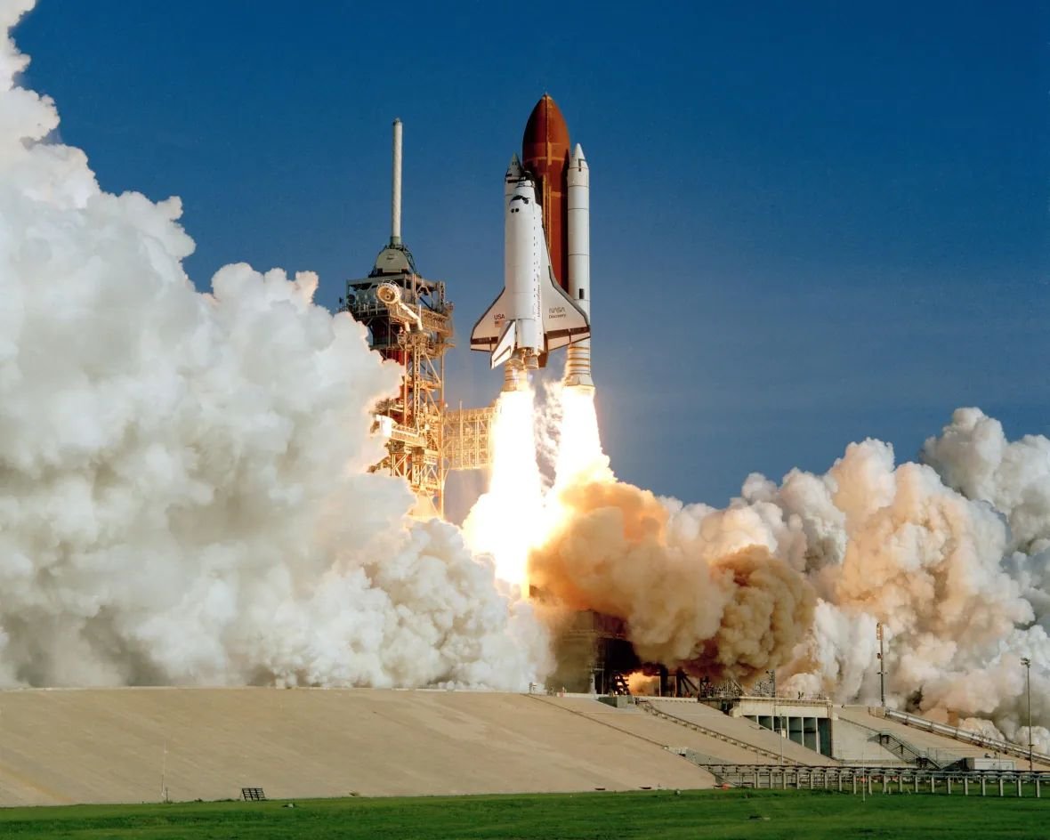 Space Shuttle Discovery soars away from Launch Pad 39A at the Kennedy Space Center, on Aug. 30, 1984, beginning its maiden voyage and a storied spaceflight career that spanned more than 26 years. The launch vehicle consisted of a main engine tank (orange) and two solid rocket boosters (white). (NASA)